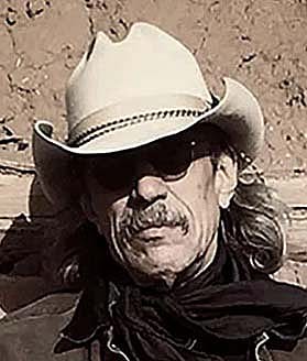Headshot of Jim Arndt in light-colored, small brimmed cowboy hat with a dark bandana.